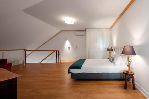 a bedroom with a bed, chair and a lamp at Palácio Camões - Lisbon Serviced Apartments in Lisbon