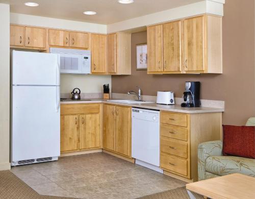 a kitchen with white appliances and wooden cabinets at WorldMark Seaside in Seaside