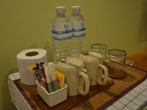 a wooden tray with two bottles of water and cups at Phuket Campground in Mai Khao Beach