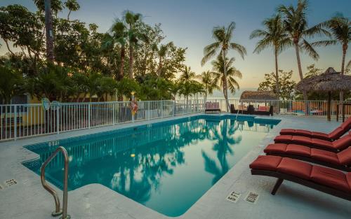 a pool at a resort with chairs and palm trees at Atlantic Bay Resort in Key Largo