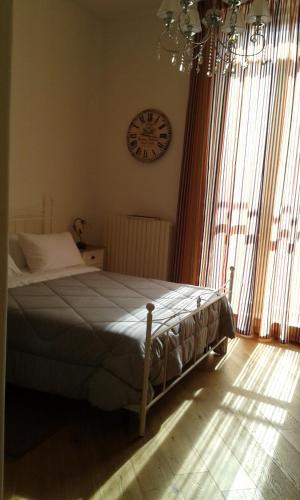 een slaapkamer met een bed en een klok aan de muur bij Il Nuovo in San Severo