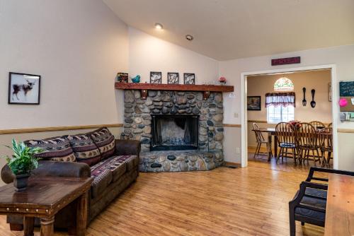 a living room with a couch and a stone fireplace at Inside Yosemite Winter Wonderland in Yosemite West