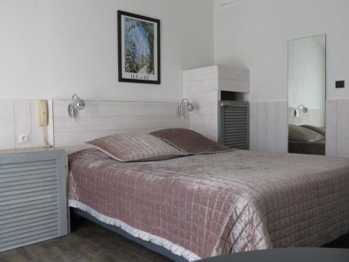 a bedroom with a large bed and a fireplace at Le Parasol in Ars-en-Ré