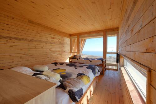 two beds in a wooden room with a window at Casa Mirador Roca in Matanzas