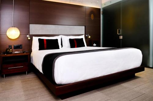 a large bedroom with a large bed with white sheets at Hercor Hotel - Urban Boutique in Chula Vista