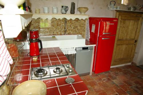 ÉcommoyにあるMaison de vacancesのキッチン(コンロ、赤い冷蔵庫付)