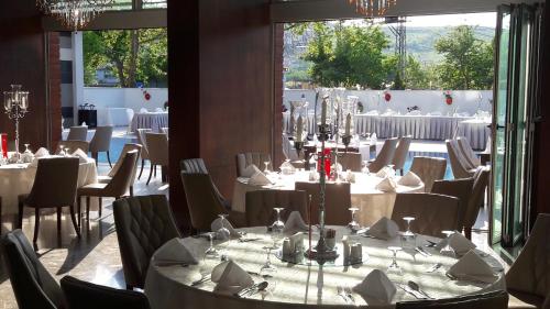 a dining room with tables and chairs and a large window at Yalova Lova Hotel & SPA Yalova in Yalova
