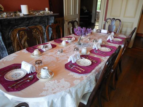 a dining room table with a pink and white table cloth at Proctor Mansion Inn in Wrentham