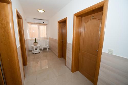Un pasillo con dos puertas de madera y una mesa. en Rooms Kenedy, en Međugorje