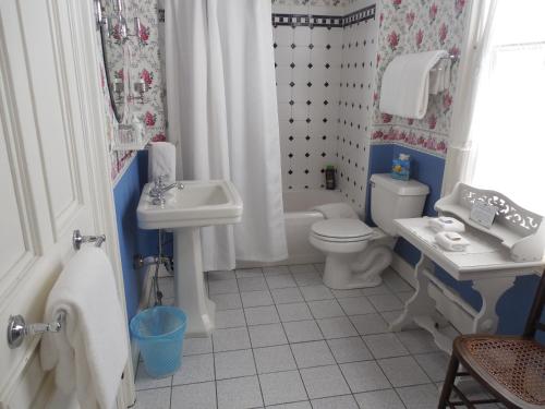 a toy bathroom with a sink and a toilet and a tub at Proctor Mansion Inn in Wrentham