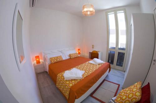 a small white room with a bed and a window at SunMoon in Reggio di Calabria