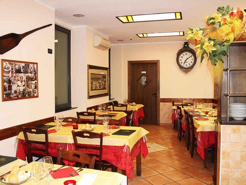 ジェノヴァにあるDa Marcelloの壁掛け時計のあるテーブル付きレストラン