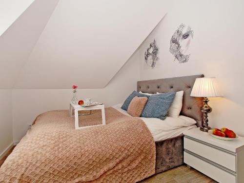 a bedroom with a bed with a table on it at Apartament Kameralny 65 na Starówce in Gdańsk