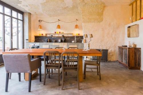 une salle à manger avec une grande table et des chaises en bois dans l'établissement Amboise Troglodyte Villa, à Pocé-sur-Cisse