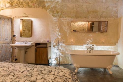 une salle de bain avec une baignoire et un lavabo dans l'établissement Amboise Troglodyte Villa, à Pocé-sur-Cisse