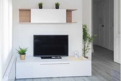 - une télévision assise sur un comptoir blanc dans le salon dans l'établissement Apartamento del Sueño con Aire Acondicionado, à Logroño