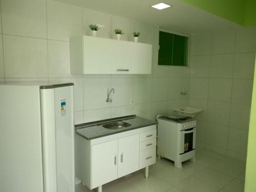 a white kitchen with a sink and a refrigerator at Hotel Letiva Arco in Sobral