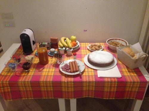 einen Tisch mit einem Tischtuch mit Essen drauf in der Unterkunft Trento nel Verde in Trient