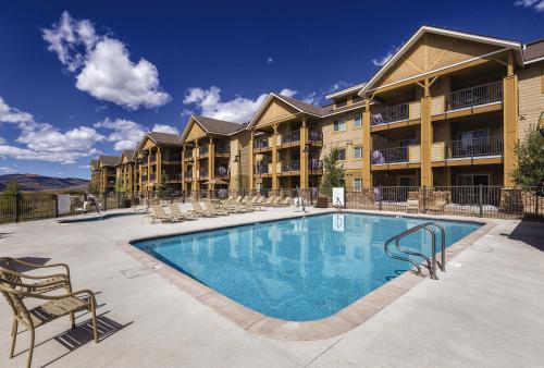 格蘭比的住宿－WorldMark Granby - Rocky Mountain Preserve，一座带椅子的度假村的游泳池和一座建筑