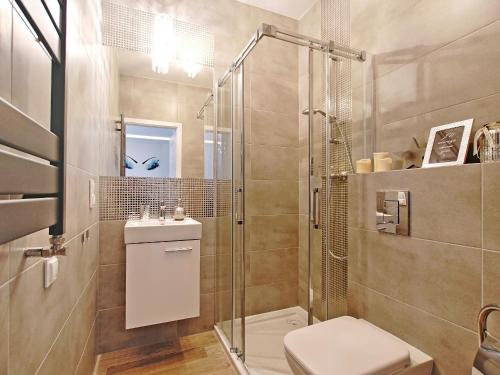 a bathroom with a shower and a toilet and a sink at Apartament Starogdański 7 in Gdańsk