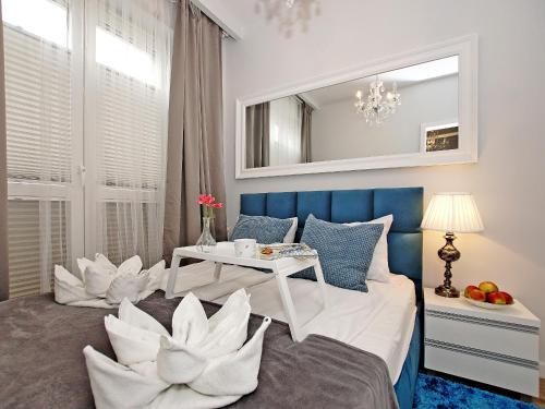 a bedroom with a bed with white pillows and a table at Apartament Starogdański 7 in Gdańsk