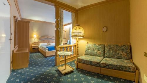 a hotel room with a bed and a couch at Garni Toni in Ortisei