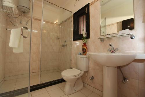 uma casa de banho com um WC, um lavatório e um chuveiro em Hotel Kridha Residency - Opposite Prem Mandir Vrindavan em Matura