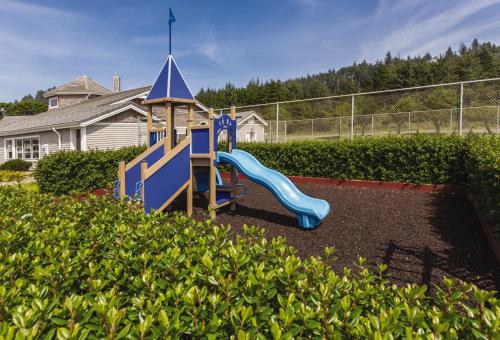 a playground with a blue slide in a yard at WorldMark Depoe Bay in Depoe Bay