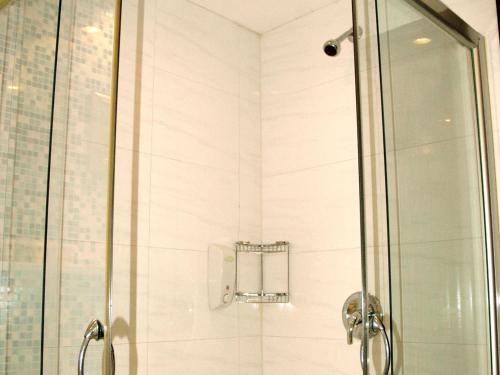 a shower stall with a glass door and a shower at Donghu Guest House in Shanghai