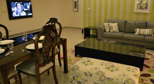 a living room with a table and chairs and a couch at City Rose Hotel Suites in Amman