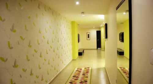 a hallway with a wall with green leaves on it at City Rose Hotel Suites in Amman