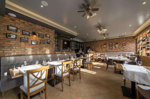 un restaurante con mesas y sillas y una pared de ladrillo en Rooms The King's Pub en Kutina