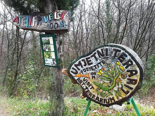 a sign with a lizard on it next to a tree at Apartment Natali in Brseč