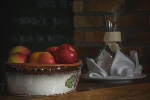 a bowl of apples on a table next to a plate at Rooms The King's Pub in Kutina
