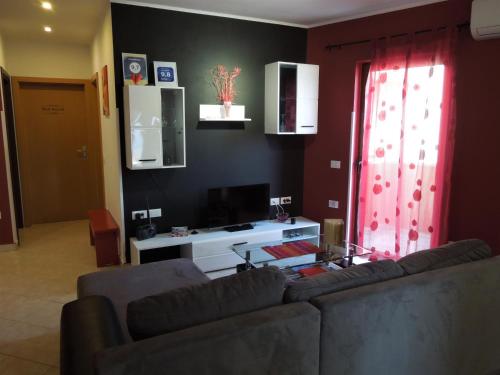 uma sala de estar com um sofá e uma televisão em Provvidenza em Motovun