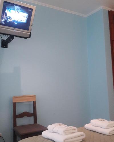 a room with two beds and a tv on a wall at Hotel Antartida Argentina in Ushuaia