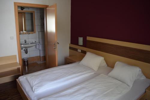 um quarto com uma cama branca e um lavatório em Pension Seeblick em Mörbisch am See