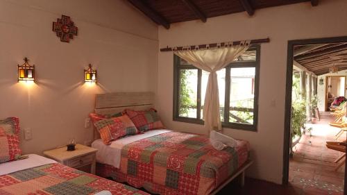 a bedroom with a bed and a window at Villa Mimi in Otavalo