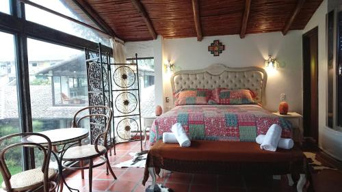 a bedroom with a bed and a table and chairs at Villa Mimi in Otavalo