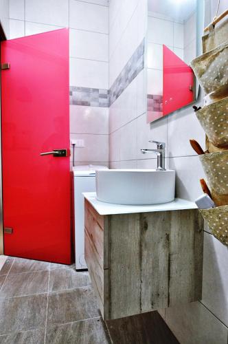 a bathroom with a sink and a red door at On The Beach in Ierapetra