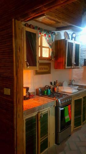 a kitchen with a stove and a counter top at Cabañas Mannan in Tanchachín