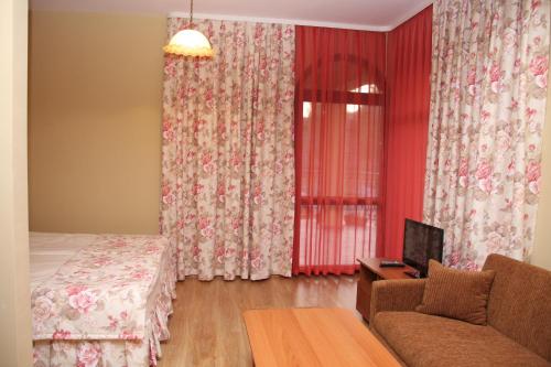 Habitación con sofá, cama y ventana en Guest House Stelia, en Velingrad