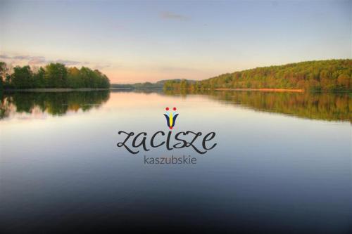 a logo on a body of water with trees in the background at Kaszubskie Zacisze in Chmielno