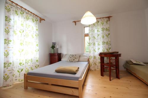 a bedroom with a bed and a table and a window at Apartament u Wolskich in Krościenko