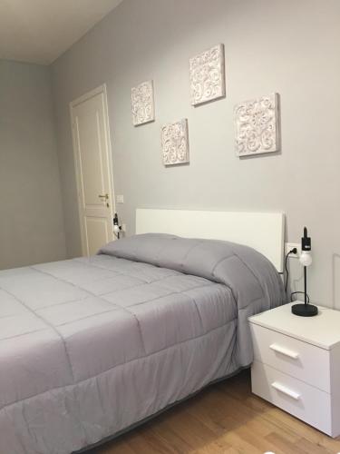 a bedroom with a bed and a nightstand and pictures on the wall at Sonny apartments in Malcesine