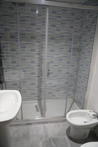 a bathroom with a toilet, sink and shower at Pension Perez in Portomarin