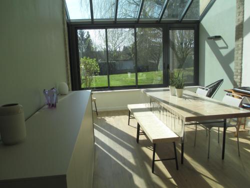 d'une salle à manger avec une table, des chaises et une fenêtre. dans l'établissement Chambre d'hôtes B&B, à Moncel-sur-Seille