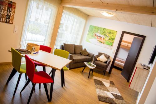 sala de estar con mesa, sillas y sofá en Alpenapart Singer - contactless check-in en Reutte