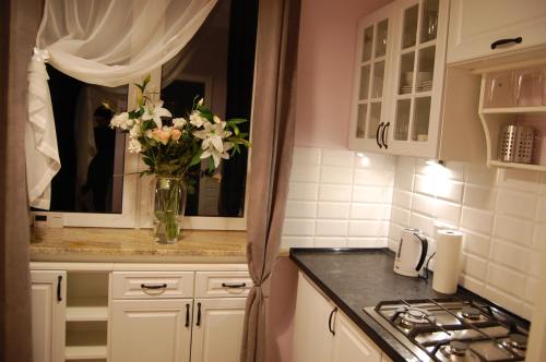 una cocina con un jarrón de flores en un mostrador en Oranger Studio, en Kielce