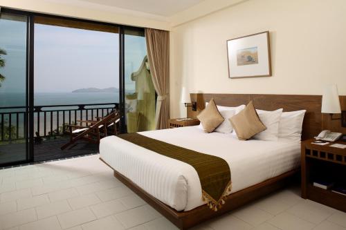 a hotel room with a bed and a balcony at Supalai Scenic Bay Resort And Spa, SHA Extra Plus in Por Bay